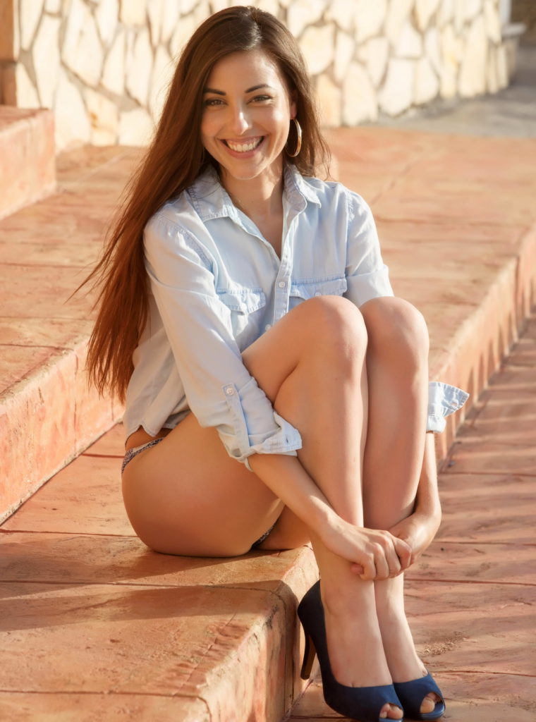 Smiling Brunette Sitting On The Stairs